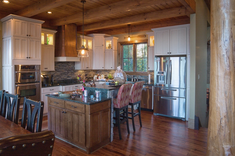 rustic lake house kitchen with timber framed ceiling and round cypress logs