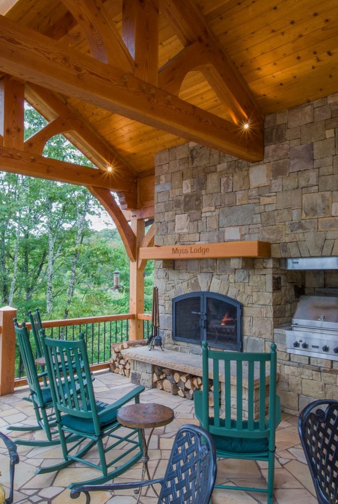 Mountain home timber frame porch with rock fireplace