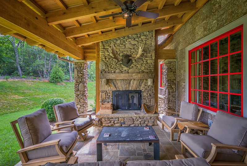 post and beam porch with outdoor fireplace and poplar bark siding